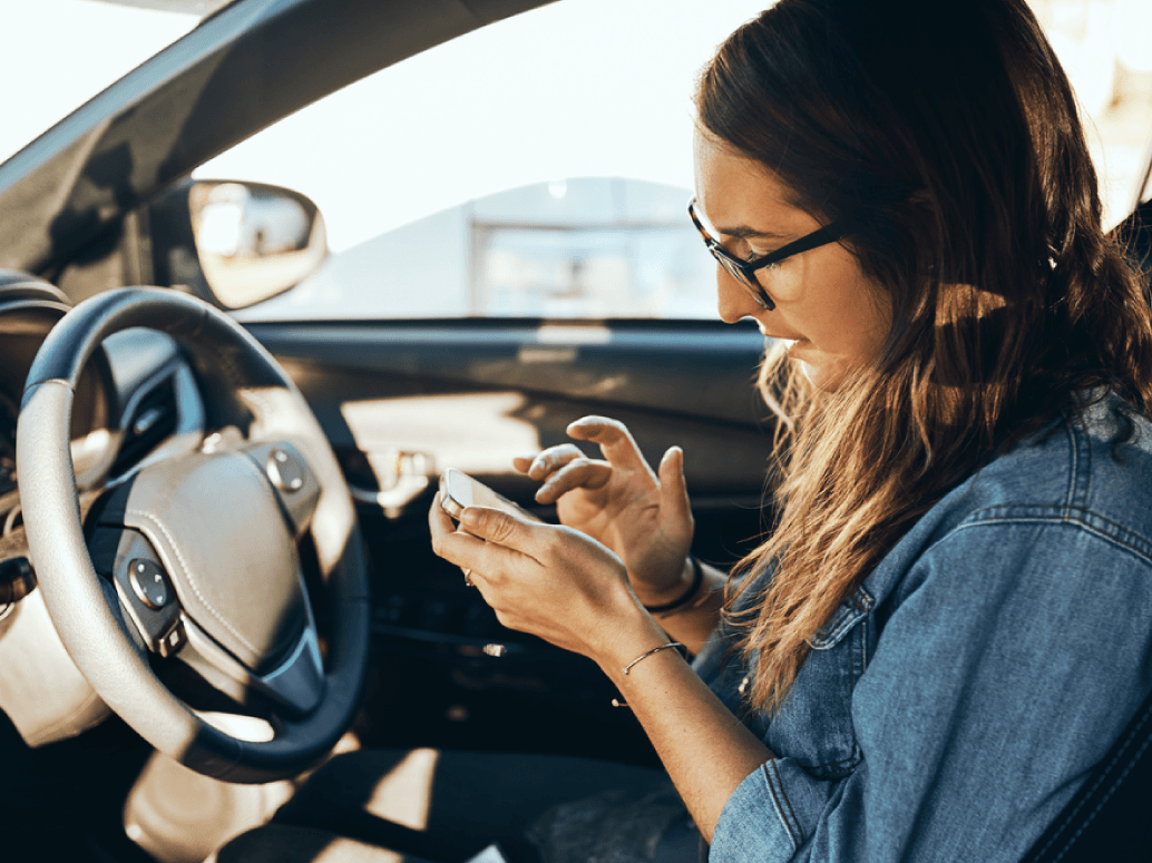 A woman calculating car lease fees in her car